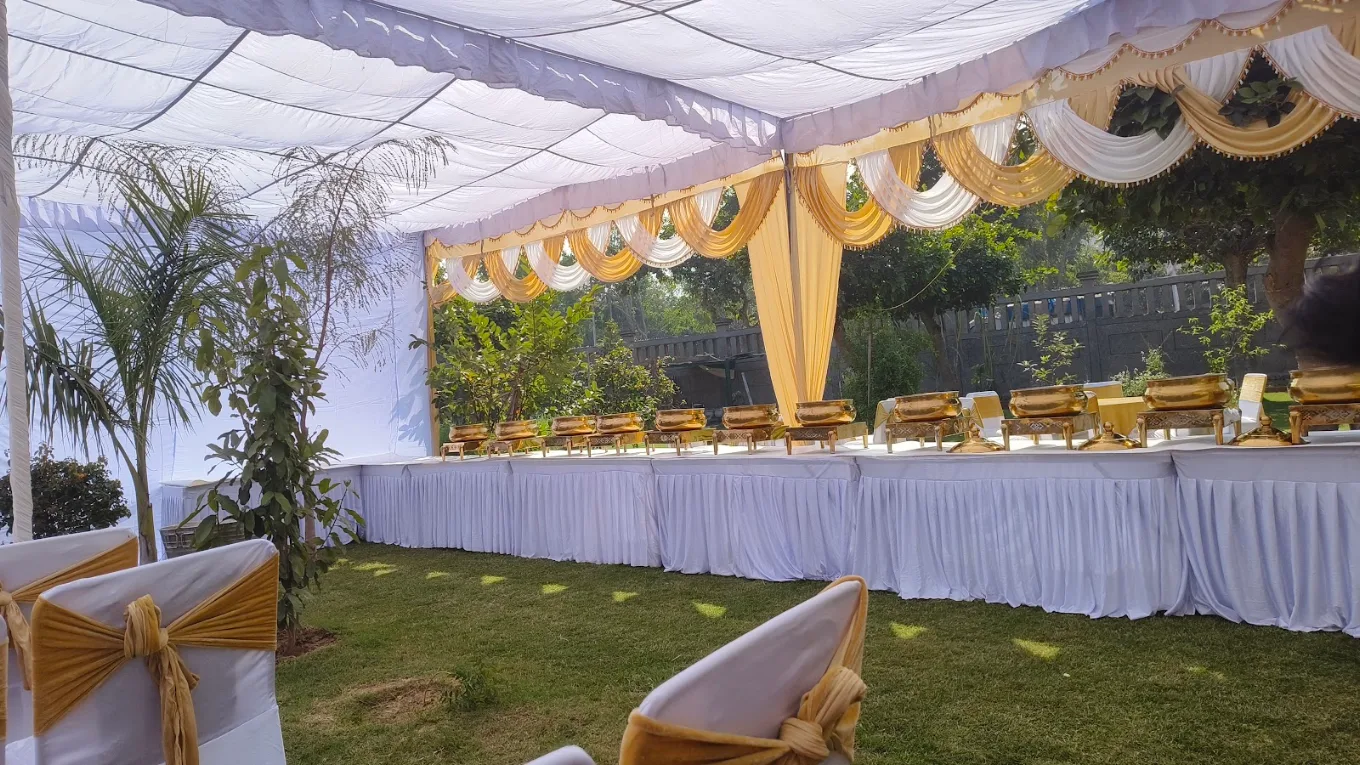 White and gold tent house setup with chafing dishes