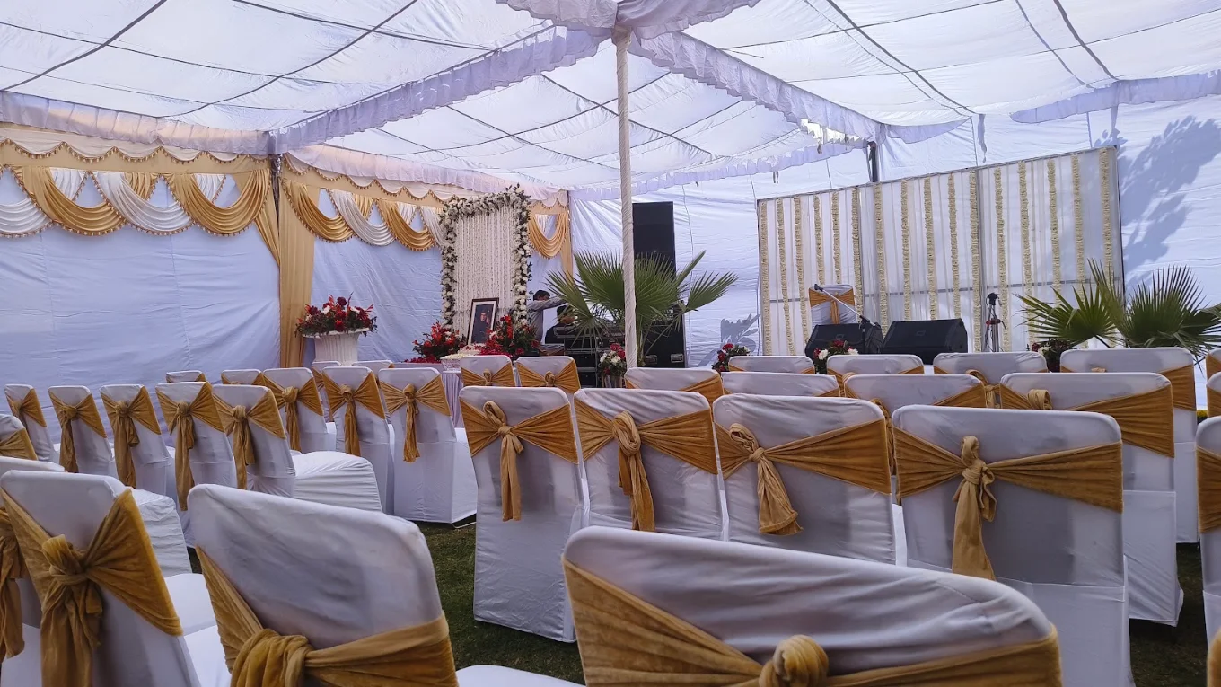 Wedding tent with gold sashes and floral stage