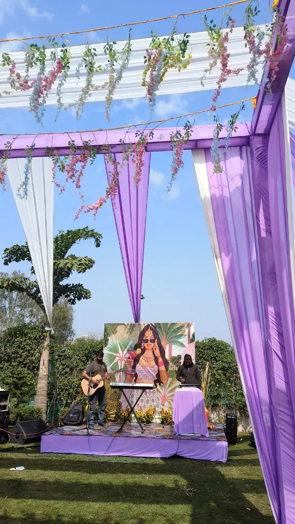 Purple mandap with floral hangings and live music stage